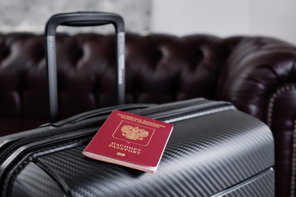 russian passport on a black travel suitcase with emigration of russians and problems with visas